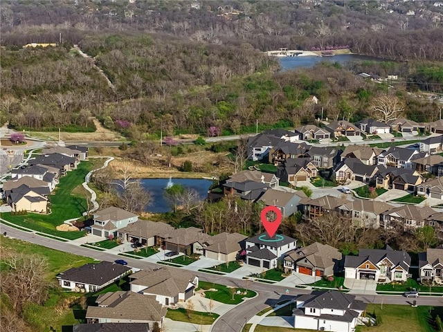 birds eye view of property featuring a water view, a view of trees, and a residential view