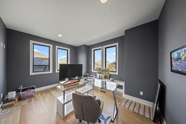 office featuring baseboards and light wood-style flooring