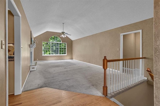 120 NW Whitlock Dr, Lees Summit, MO 64081 - unfurnished living room featuring a ceiling fan, lofted ceiling, a textured ceiling, wood finished floors, and baseboards