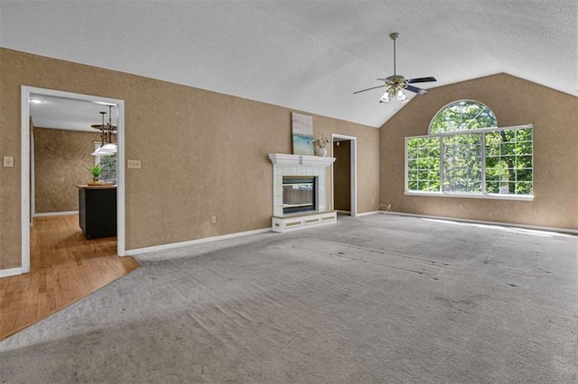 120 NW Whitlock Dr, Lees Summit, MO 64081 - unfurnished living room with a ceiling fan, carpet floors, lofted ceiling, a tile fireplace, and baseboards