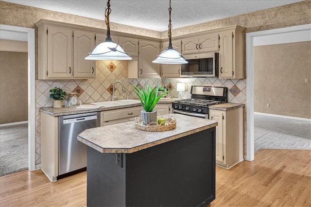 120 NW Whitlock Dr, Lees Summit, MO 64081 - kitchen with appliances with stainless steel finishes, light countertops, light wood-type flooring, baseboards, and a textured ceiling