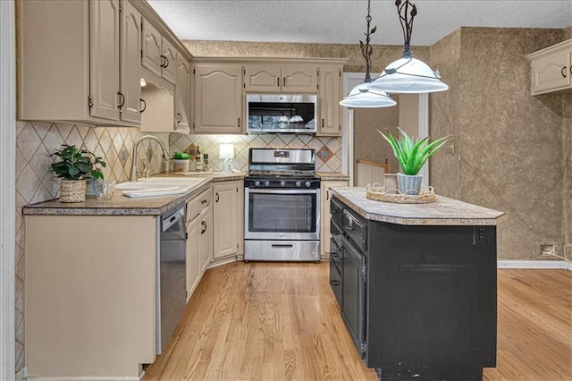 120 NW Whitlock Dr, Lees Summit, MO 64081 - kitchen with stainless steel appliances, a sink, light wood-style flooring, a center island, and pendant lighting