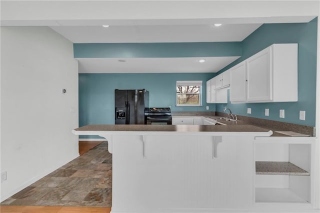 24101 S State Route K, Pleasant Hill, MO 64080 - kitchen featuring black appliances, a sink, a peninsula, white cabinetry, and a breakfast bar area
