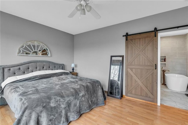 24101 S State Route K, Pleasant Hill, MO 64080 - bedroom with a barn door, light wood-style flooring, and ceiling fan