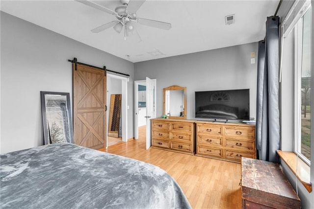 24101 S State Route K, Pleasant Hill, MO 64080 - bedroom with a barn door, wood finished floors, and ceiling fan