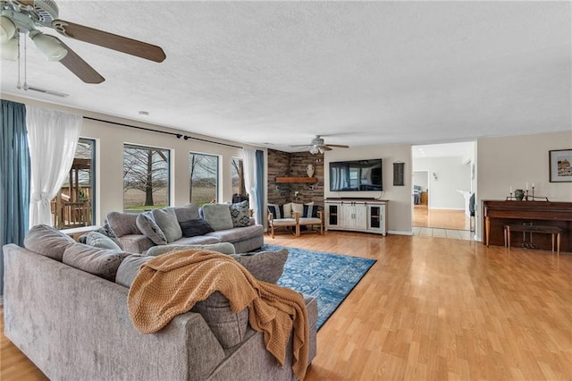 24101 S State Route K, Pleasant Hill, MO 64080 - living room featuring a ceiling fan, light wood-type flooring, a textured ceiling, and baseboards