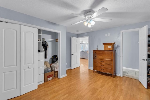 24101 S State Route K, Pleasant Hill, MO 64080 - bedroom with light wood-style flooring, a closet, a textured ceiling, baseboards, and a ceiling fan