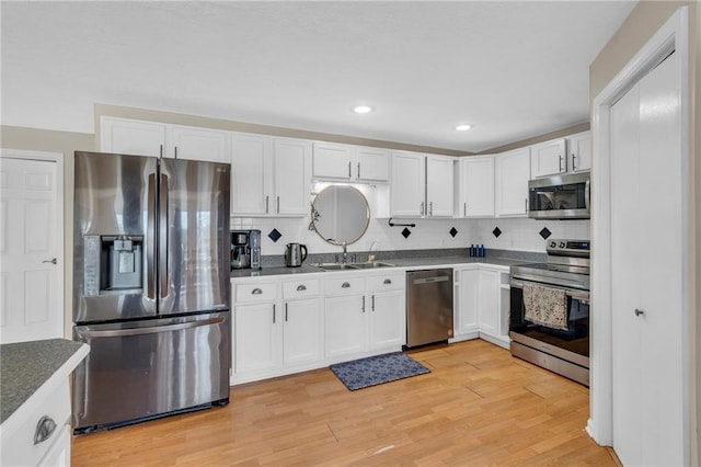 24101 S State Route K, Pleasant Hill, MO 64080 - kitchen featuring stainless steel appliances, a sink, white cabinetry, tasteful backsplash, and recessed lighting
