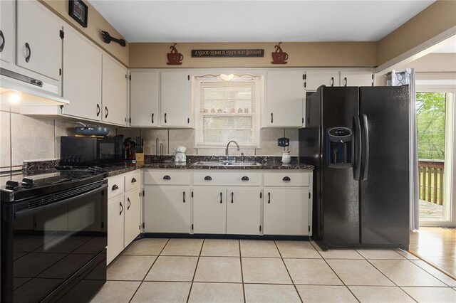 kitchen with light tile patterned floors, under cabinet range hood, a sink, and black appliances