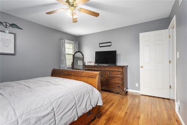 bedroom featuring wood finished floors, a ceiling fan, and baseboards