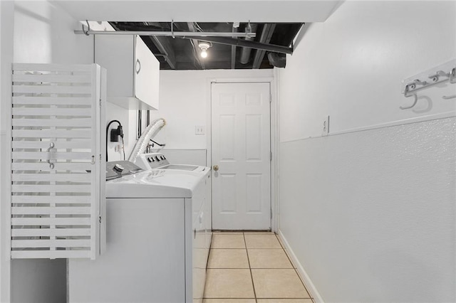 laundry area with baseboards, washer and clothes dryer, laundry area, and light tile patterned floors
