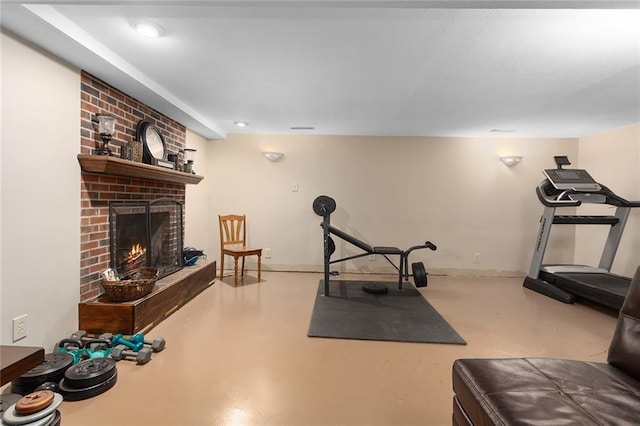 workout room featuring a fireplace and baseboards