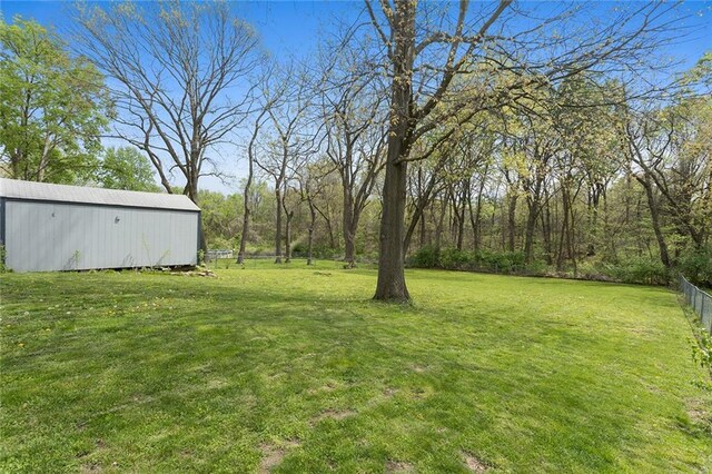 view of yard featuring fence, an outbuilding, and an outdoor structure