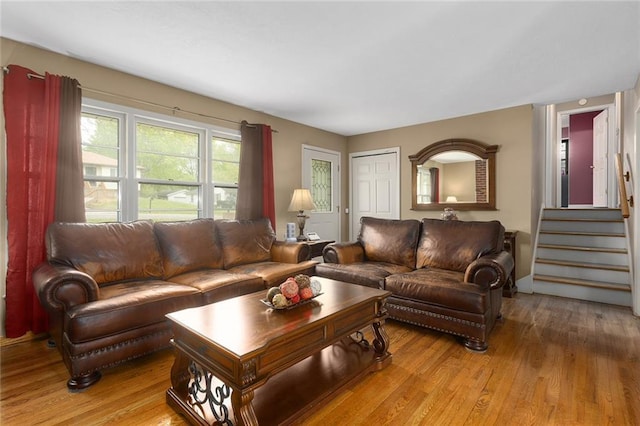 living area with light wood-style floors and stairway