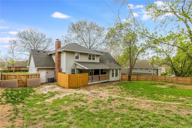6806 N Euclid Ave, Kansas City, MO 64119 - rear view of house with a yard, a chimney, and a fenced backyard