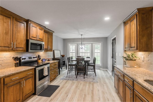6806 N Euclid Ave, Kansas City, MO 64119 - kitchen featuring brown cabinets, stainless steel appliances, recessed lighting, and light wood-style floors