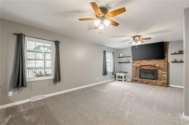 6806 N Euclid Ave, Kansas City, MO 64119 - unfurnished living room featuring carpet floors, a brick fireplace, a ceiling fan, baseboards, and visible vents