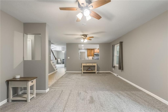 6806 N Euclid Ave, Kansas City, MO 64119 - living room with a ceiling fan, baseboards, light carpet, and stairway
