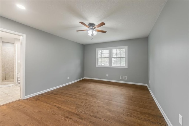 6806 N Euclid Ave, Kansas City, MO 64119 - spare room featuring ceiling fan, a textured ceiling, baseboards, wood finished floors, and visible vents