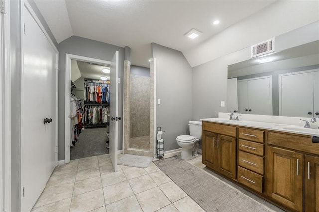 6806 N Euclid Ave, Kansas City, MO 64119 - bathroom with a tile shower, a sink, visible vents, toilet, and vaulted ceiling