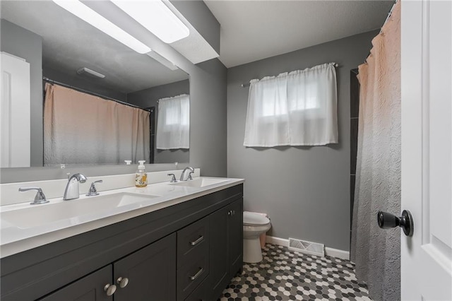 6806 N Euclid Ave, Kansas City, MO 64119 - bathroom featuring toilet, baseboards, visible vents, and a sink