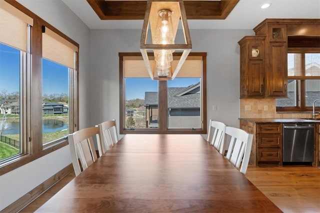 unfurnished dining area featuring wood finished floors, a sink, recessed lighting, and baseboards