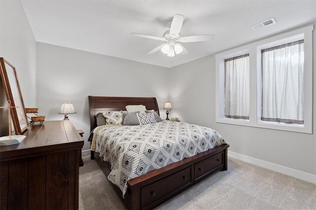 bedroom featuring baseboards, light colored carpet, and a ceiling fan