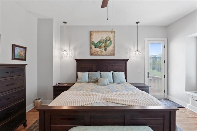 bedroom featuring access to outside, baseboards, wood finished floors, and ceiling fan