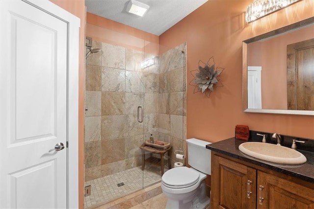 bathroom featuring a stall shower, toilet, and vanity