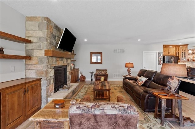 living area with a fireplace, recessed lighting, and light wood-style flooring