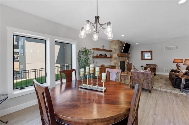 dining space with light wood-style flooring, baseboards, and a fireplace