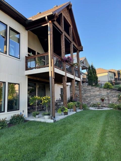 rear view of property featuring a balcony and a patio area