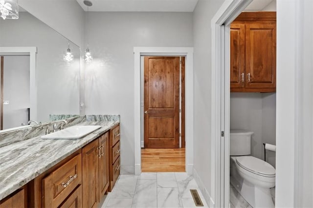 8856 Freedom St, Lenexa, KS 66227 - bathroom with marble look tiles, vanity, toilet, and baseboards