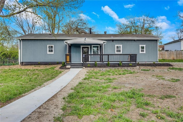 view of front of property featuring a front lawn, fence, and covered porch