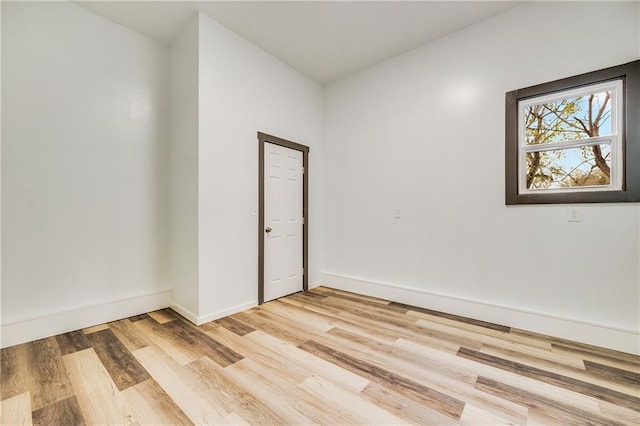 unfurnished room with light wood finished floors and baseboards