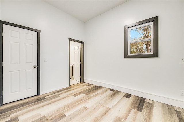 unfurnished bedroom with light wood-type flooring and baseboards