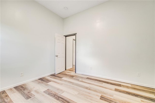 unfurnished room featuring baseboards and light wood-type flooring