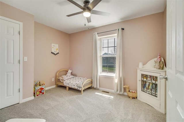 carpeted bedroom with baseboards, a ceiling fan, and visible vents
