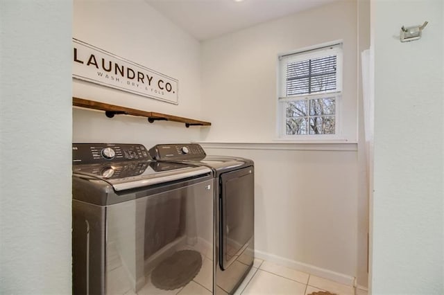 washroom with independent washer and dryer, light tile patterned flooring, laundry area, and baseboards