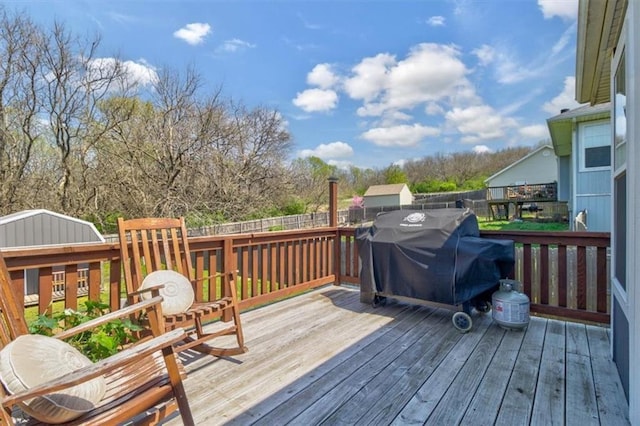 wooden deck with a grill and fence
