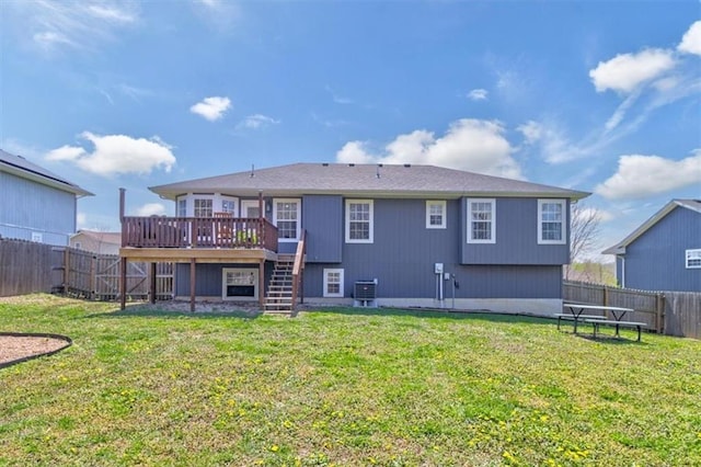 back of property with a lawn, a fenced backyard, stairway, and central AC