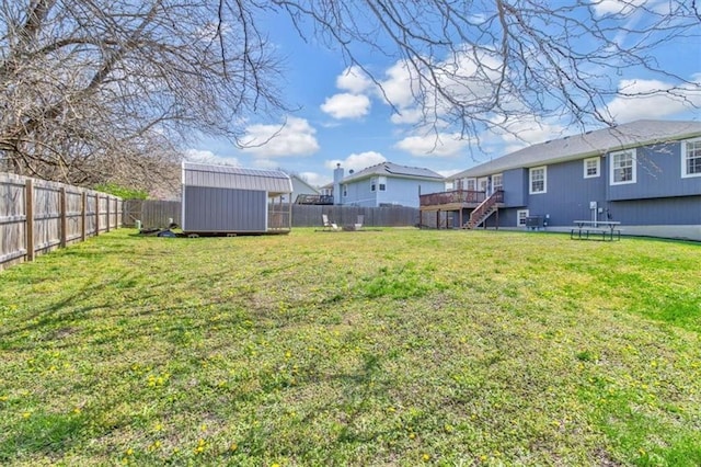 view of yard featuring a fenced backyard, a shed, an outdoor structure, and stairway