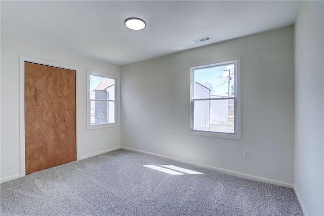 unfurnished bedroom featuring baseboards, multiple windows, and carpet floors