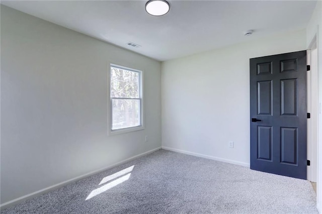 spare room featuring visible vents, baseboards, and carpet flooring