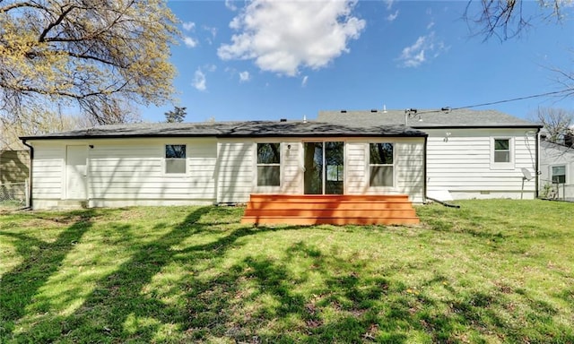 rear view of property featuring fence and a lawn