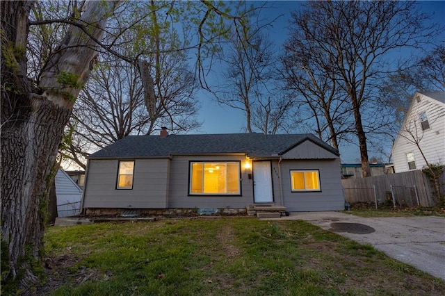 9904 E 60th Ter, Raytown, MO 64133 - view of front of property with roof with shingles, a chimney, a front yard, and fence