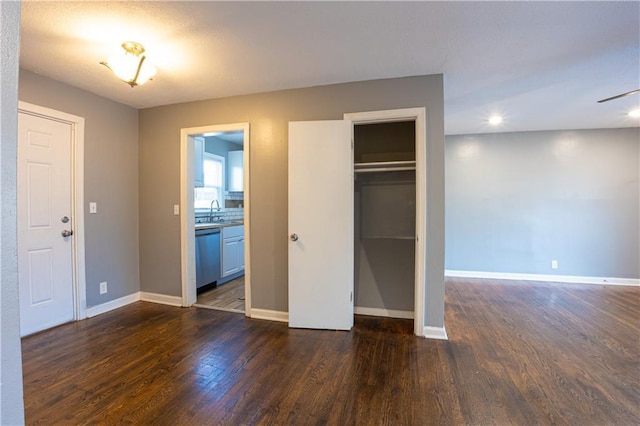 9904 E 60th Ter, Raytown, MO 64133 - unfurnished bedroom with dark wood-type flooring, a sink, baseboards, and recessed lighting
