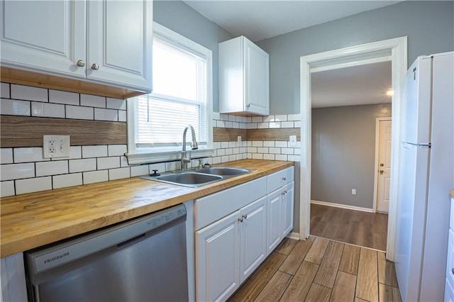 9904 E 60th Ter, Raytown, MO 64133 - kitchen featuring dishwasher, a sink, freestanding refrigerator, butcher block counters, and white cabinetry