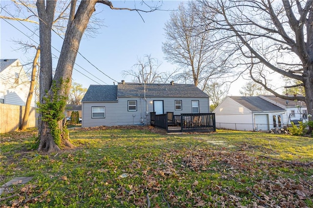 9904 E 60th Ter, Raytown, MO 64133 - back of property with a shingled roof, a wooden deck, fence, and a lawn
