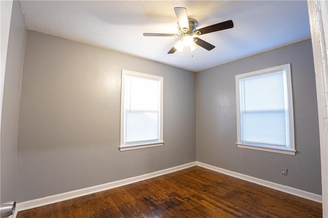 9904 E 60th Ter, Raytown, MO 64133 - empty room featuring dark wood-style flooring, baseboards, a ceiling fan, and plenty of natural light